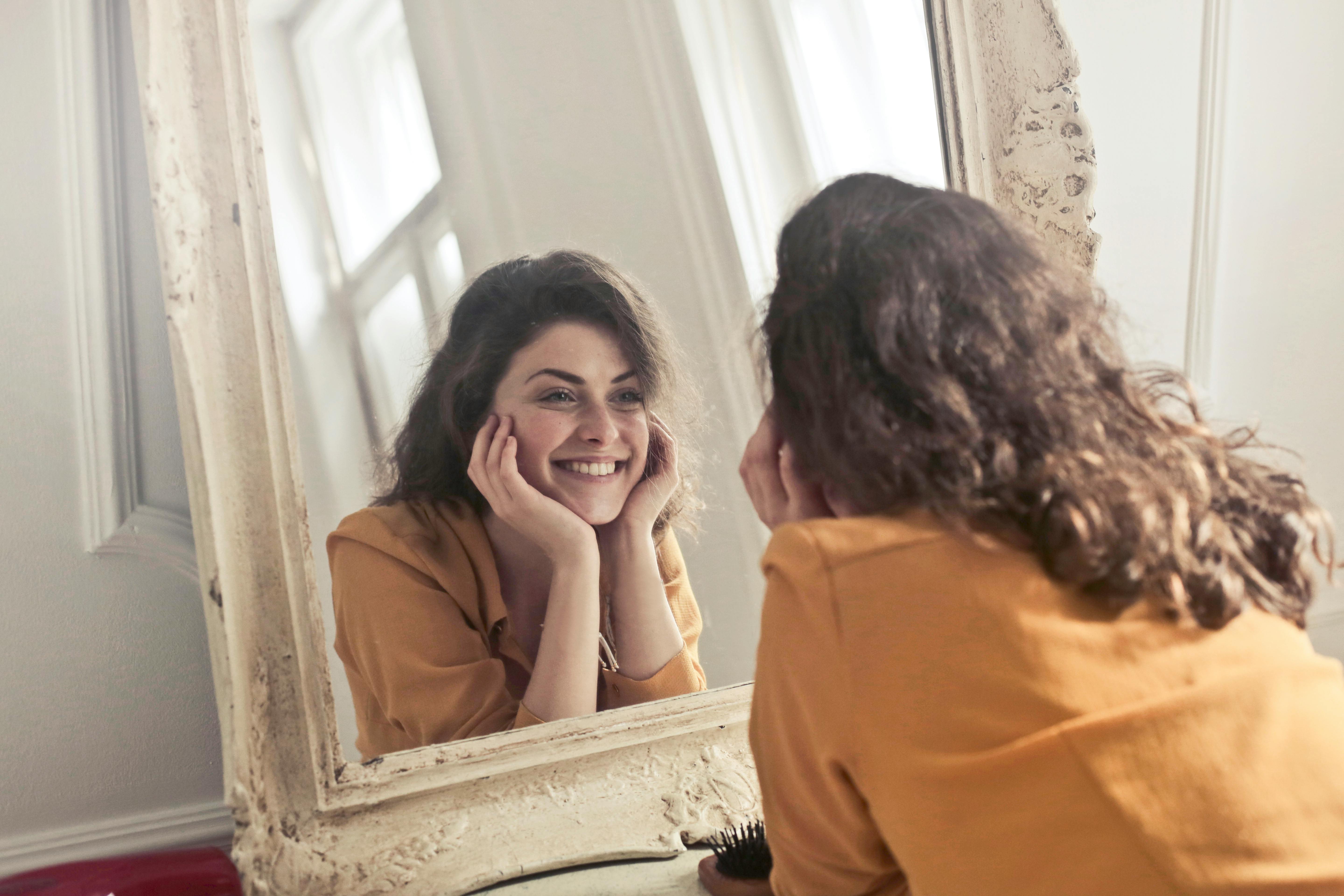 Una donna che si guarda allo specchio con positività