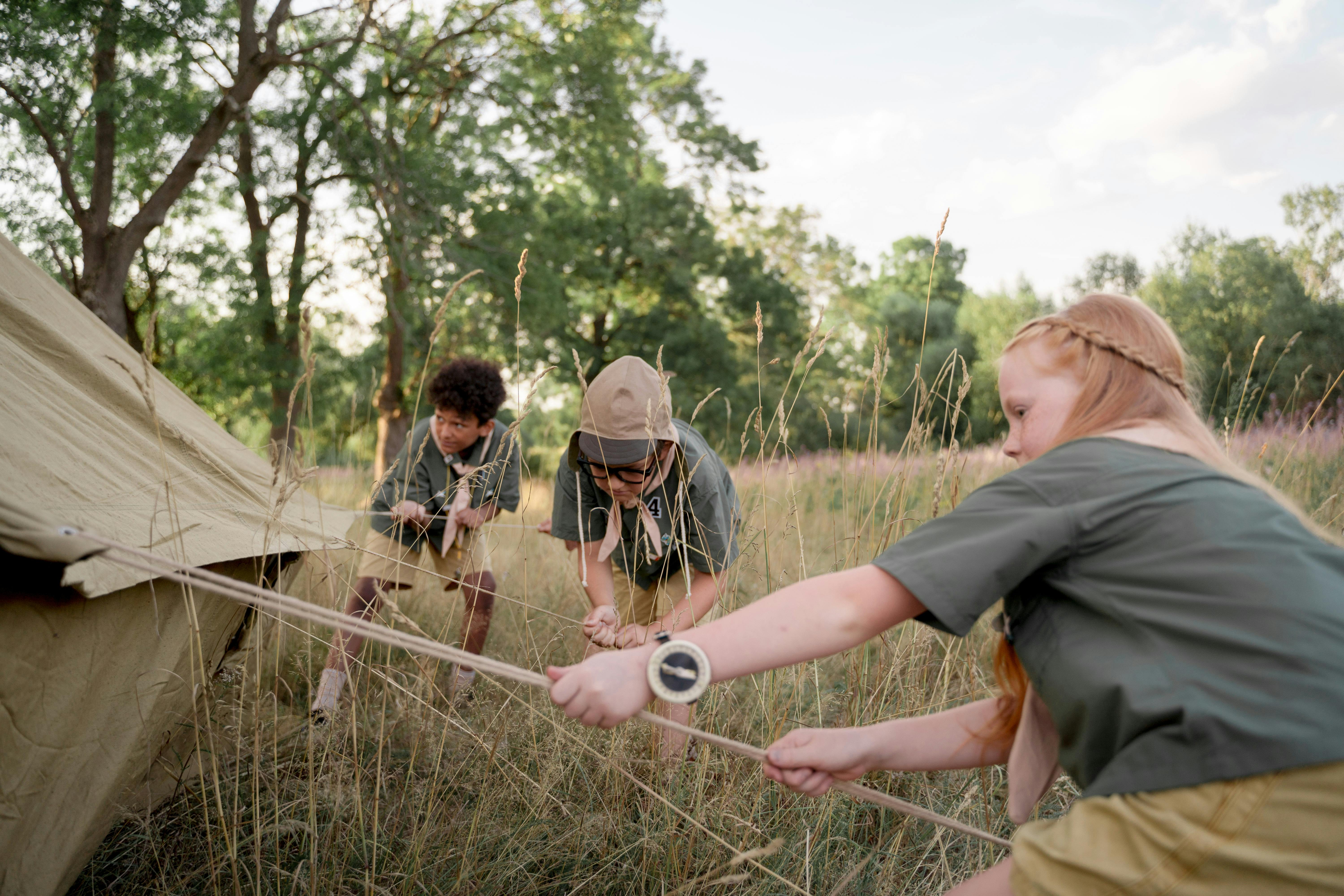 Un gruppo di scout monta una tenda durante un'uscita nella natura