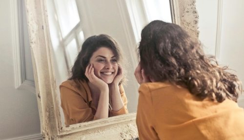 Una donna che si guarda allo specchio con positività